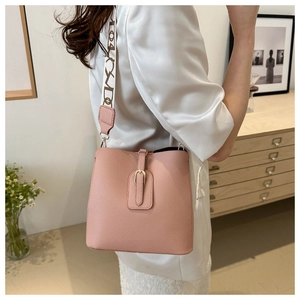 Detail of pink leather bucket bag worn by model in a natural indoor lifestyle setting