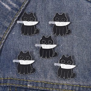 Macro detail of five black cat enamel pins with pronouns on denim background