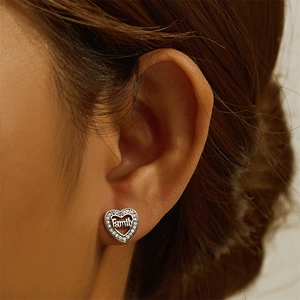 Macro shot of S925 sterling silver heart-shaped stud earring with Family engraving