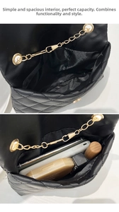 Detail showing internal capacity of the black quilted small bag with chain strap