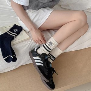 Vintage athletic striped mid-tube cotton socks with letter embroidery on white bed
