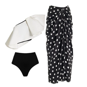 Three-piece black and white swimwear set with ruffles and polka dot sarong wrap skirt
