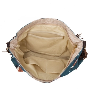 Internal detail of woven tote bag showing fabric lining, zipper pocket, and open slots