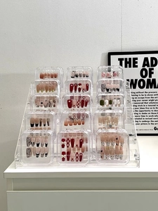 Clear acrylic display case showcasing various press-on nail styles and patterns