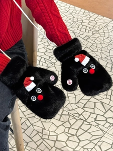 Close-up of black faux fur winter mittens featuring a red Santa hat and plush deer nose