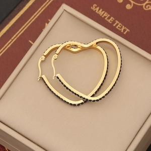 Golden heart hoop earrings with black pavé crystals in a beige jewelry display box