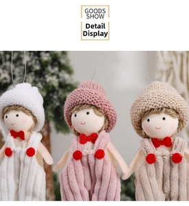 Detail of Christmas knitted dolls with corduroy overalls and bows for tree decoration