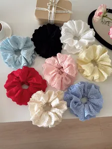 Flat lay of 8 colorful lace scrunchies with floral embroidery on white background