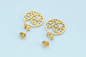 Detailed view of gold-tone hollow flower earrings with intricate circular patterns