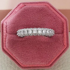 Macro shot of silver eternity ring with zircon stones in a pink velvet jewelry box