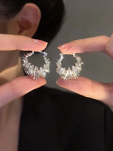 Macro view of silver fringe earrings with metallic spikes and shimmering reflection