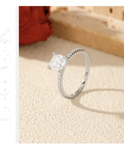 Detailed macro view of silver ring showing four-prong square-cut moissanite and pave diamonds