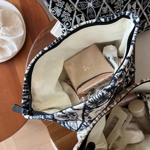 Flat lay of vintage embroidered linen makeup bag showing large capacity and zipper closure