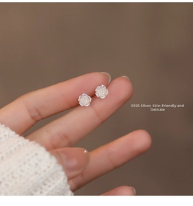 Macro view of S925 sterling silver white rose stud earrings with pearlescent finish