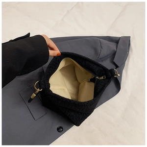 Top view of large black wool bucket bag showing beige lining and gold zipper