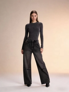 Detail der High-Waist-Jeans mit weitem Bein, Vintage-Waschung und markanten Nähten