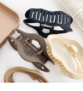 Detailed view of matte large cloud hair claws in black, brown and beige colors