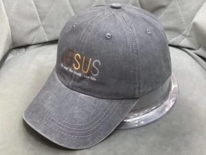 Detail of washed cotton baseball cap featuring Jesus text print and vintage gray texture