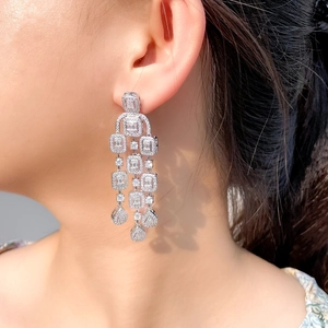 Elegant silver tassel earrings with zircon stones worn by a model in a high-fashion style