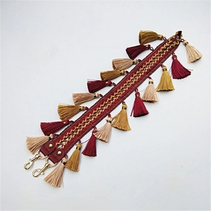 Détail de la bandoulière ethnique avec pompons colorés et attaches en métal doré