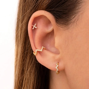 Detailed close-up of S925 silver wavy gold ear cuff and cross stud earring set with diamonds