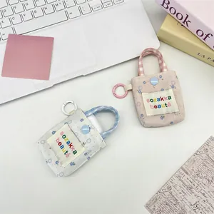 Close-up of floral mini earphone cases with fabric texture and carabiner hooks