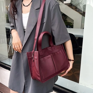 Detail of wine red tote bag with lychee texture and side pockets on a model