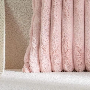 Close-up of pink faux rabbit fur pillow cover with striped texture and soft plush fabric