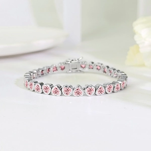 Close-up of heart-cut pink zircon tennis bracelet with silver-tone bezel setting and secure clasp