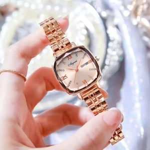 Gros plan d'une montre carrée en or rose avec index en cristal et guichet de date