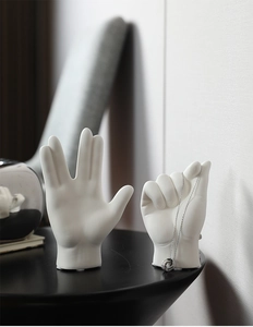 Detail of two white ceramic hand gestures for jewelry display and minimalist home decor