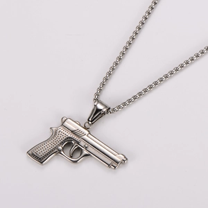 Detailed close-up of a silver-toned pistol pendant on a round box chain necklace
