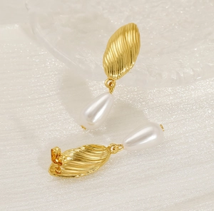Close-up of gold shell texture and drop pearl on these elegant French vintage earrings