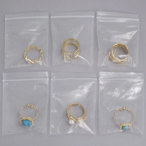 Macro detail of six vintage bohemian gold rings with turquoise stones in packaging