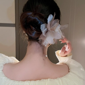 Détail d'épingle à cheveux fleur en tissu avec pompon perle sur chignon élégant