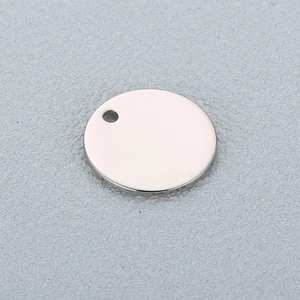 Macro shot of silver stainless steel round pendant with a small hole for DIY jewelry
