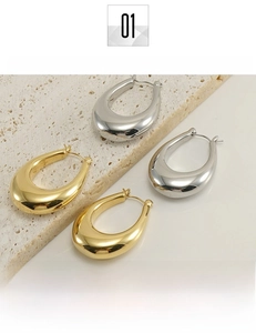 Detailed view of polished gold and silver water drop earrings on textured stone