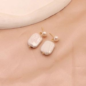 Macro detail of baroque freshwater pearl earrings featuring a natural iridescent luster