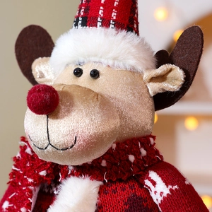 Macro view of Christmas reindeer plush with red plaid hat and cozy knit sweater detail