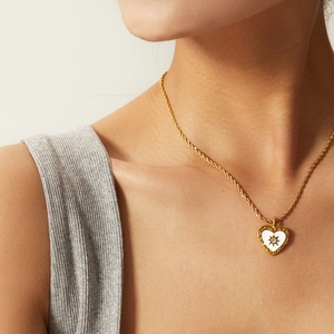 Nahaufnahme der goldenen Herzkette mit gedrehter Kette und funkelndem Stern-Anhänger
