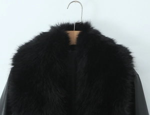 Detailed view of the black winter coat featuring a thick faux fur collar and leather texture