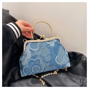 Detailed view of denim handbag with cloud jacquard patterns and rhinestone gold clasp