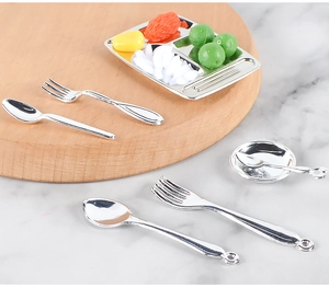 Macro detail of miniature silverware and food tray set for 1:12 scale dollhouse decor