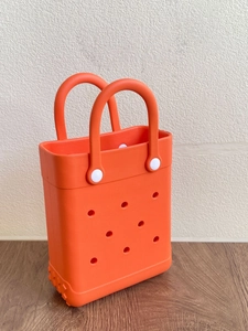 Detail shot of lightweight orange EVA beach bag showing circular holes and handle rivets