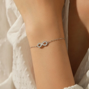 S925 sterling silver Mobius bracelet with sparkling moissanite infinity charm on wrist