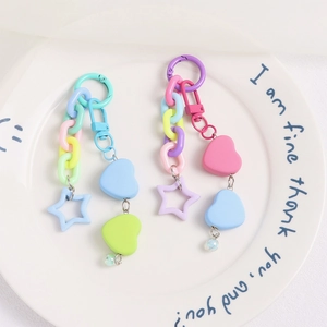 Colorful macaron heart and star chain keychains on a white decorative plate