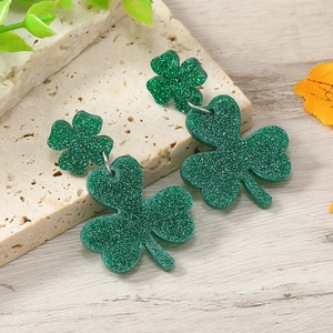 Detail of dark green glitter shamrock earrings with double-layered clover on stone