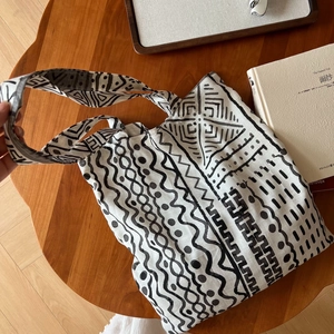 Sac fourre-tout en toile bohème avec motifs tribaux noirs sur une table en bois