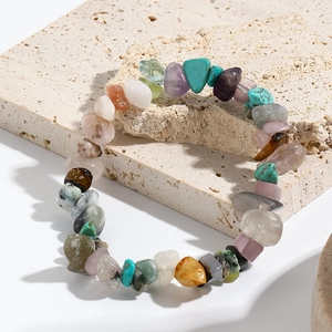 Macro shot of colorful mixed natural stone chips and turquoise on a beige travertine base