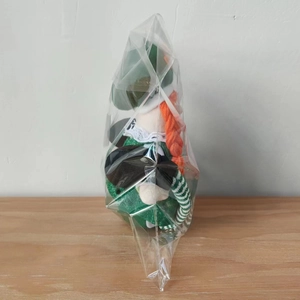 Detail of St. Patrick's Day plush doll with green glitter dress and orange braids
